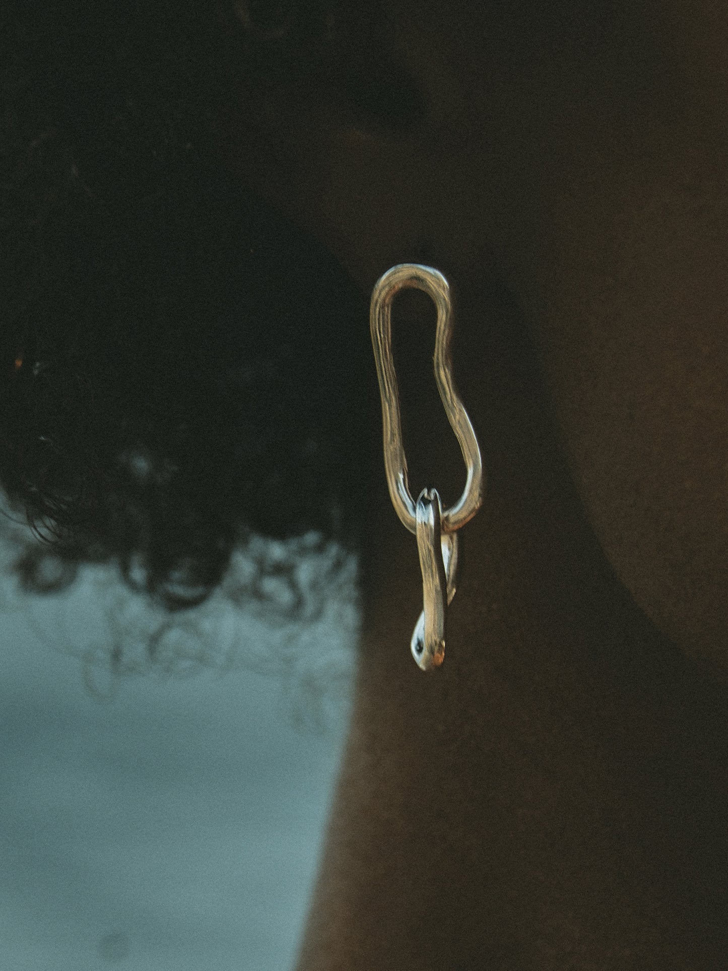 Eternity Drop Hoop Earrings. These elongated double-link earrings, crafted from a hand-forged chain by Pola, boast an organic shape that adds depth and sophistication to any look. Sterling Silver